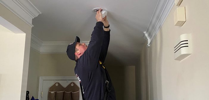 firefighter changing smoke detector