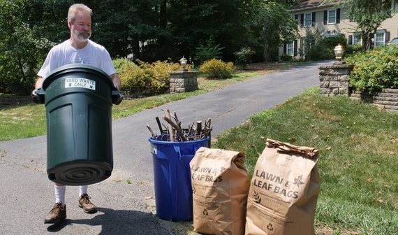 man taking yard waste to curb