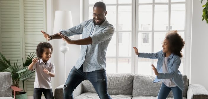 father dancing with children