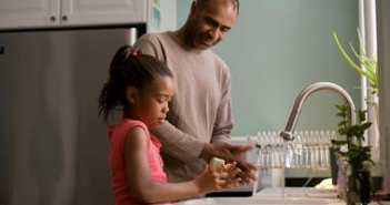 father and child at a water tap or kitchen sink