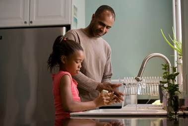 father and child at a water tap or kitchen sink
