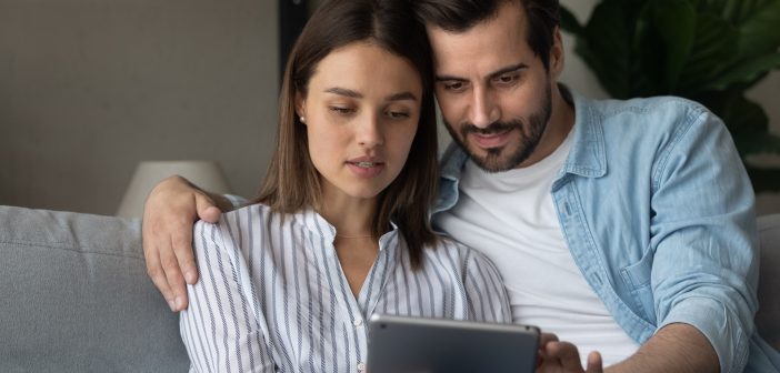 young couple looking at an ipad, finances