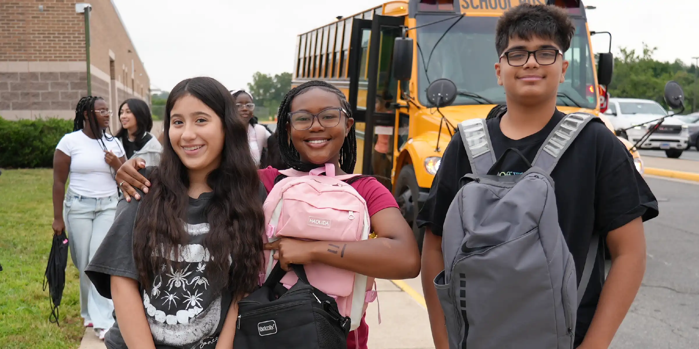 students in front of a school bus