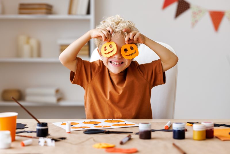 boy with little paper pumpkins
