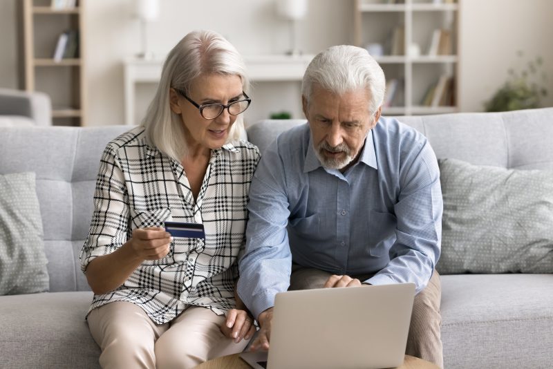 older couple, calculator, finances, laptop