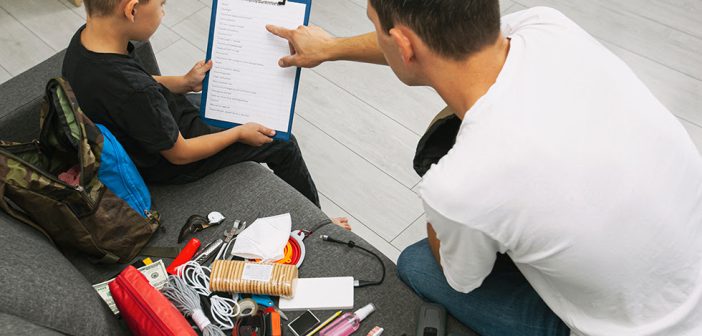 Father and son assemble the emergency evacuation bag together and put necessary items into backpacks