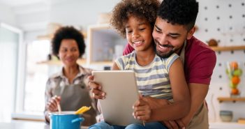 family with kid on screen and parents smiling