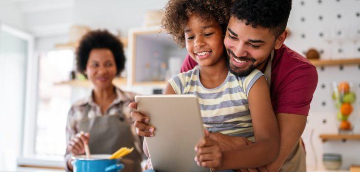 family with kid on screen and parents smiling